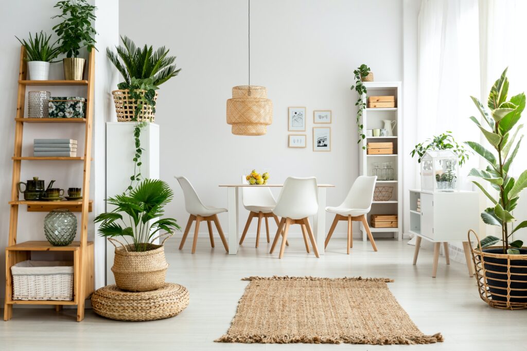 Plants and rug in natural dining room interior with white chairs